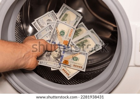 American dollars being put into the washing machine, Concept, Money laundering, Illegal business proceeds, Dark business, Black market, Bundle of 100 dollar bills