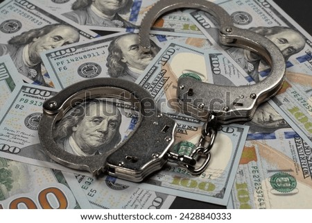 American dollars and handcuffs, Concept of ideas of corruption, dirty money or financial crimes.