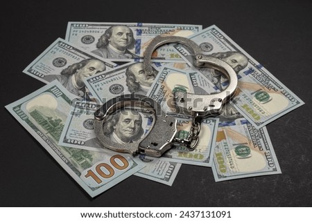 American dollars and handcuffs, Concept of ideas of corruption, dirty money or financial crimes.
