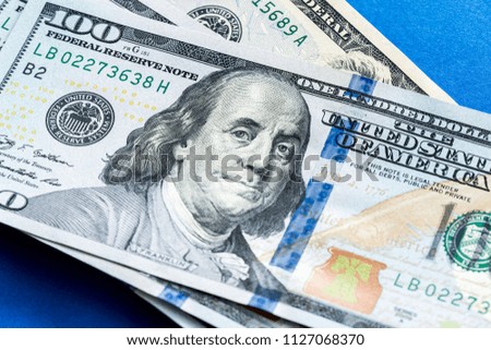American dollars. A stack of hundred dollar bills. Close up of new hundred dollar bill on the blue background.