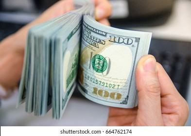 American dollars or US dollars : Asian women hand counting one hundred American money or 100 USD domination note.
