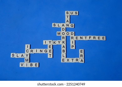 American English slang. Spelled with letter tiles on a blue background. Crossword style pattern of popular slang. Word puzzle.