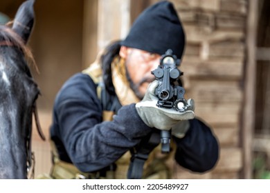 American European Military Soldier In The Battle Field Stay Hide Black Horse Aim Handgun To Enemy During War 
