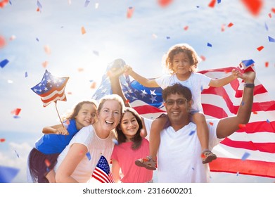 American family celebrating 4th of July. People watching Independence Day fireworks holding US flag. Proud USA crowd cheer and celebrate. Group with America symbol. National holiday party. - Powered by Shutterstock