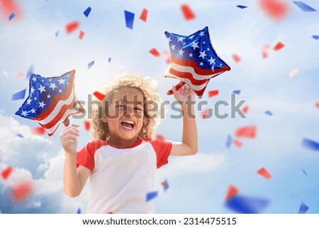 American family celebrating 4th of July. Laughing happy child watching Independence Day fireworks holding US flag balloons. Proud USA kids cheer and celebrate at party. Boy with America symbol. 