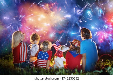 American family celebrating Independence Day. Picnic and fireworks on 4th of July in America. USA flag. Parents and kids celebrate US holiday. Children watching firework. - Powered by Shutterstock