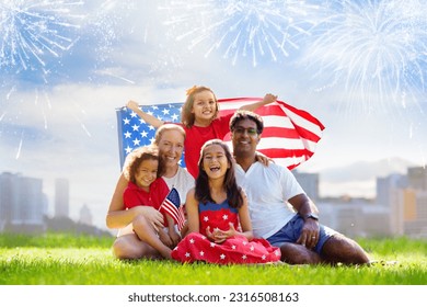 American family celebrating Independence Day. Picnic and fireworks on 4th of July in America. USA flag. Parents and kids celebrate US holiday. Children watching firework. - Powered by Shutterstock