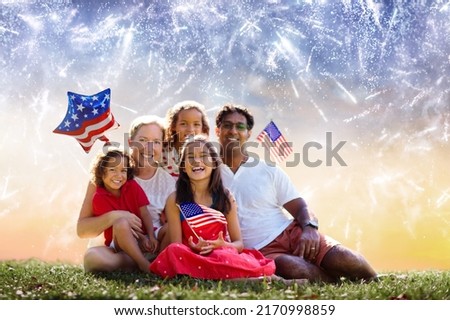 American family celebrating Independence Day. Picnic and fireworks on 4th of July in America. USA flag. Parents and kids celebrate US holiday. Children watching firework.