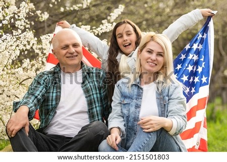 american family with USA flag outdoors.