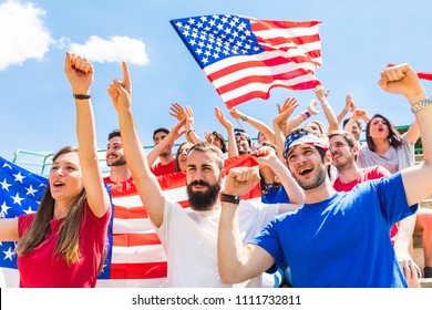 American fans cheering at stadium with USA flags. Group of supporters watching a match and cheering team USA. Sport and lifestyle concepts. - Powered by Shutterstock