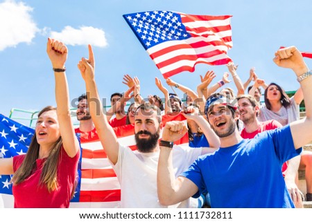 American fans cheering at stadium with USA flags. Group of supporters watching a match and cheering team USA. Sport and lifestyle concepts.