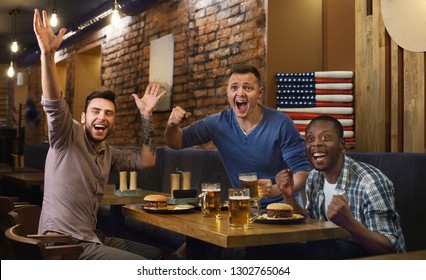 American Fans Watching Football Game And Drinking Beer At The Pub