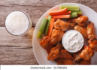 American Fast Food: Buffalo Wings With Sauce And Beer On The Table Close-up. Horizontal View From Above
