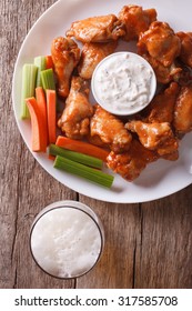 American Fast Food: Buffalo Wings With Sauce And Beer On The Table Close-up Vertical View From Above
