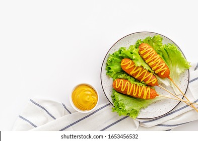 American fast food. Corn dogs on white background with mustard. Copy space, top view. - Powered by Shutterstock