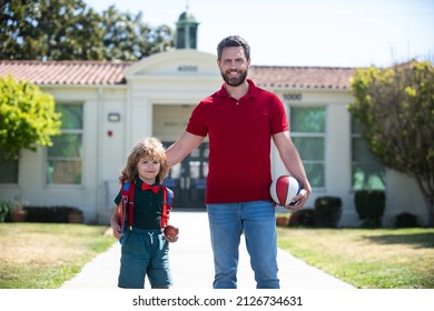 American father and son walking trough school park.