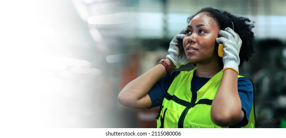 American Female Worker Wearing Safety Gear .In A Heavy Industrial Factory.