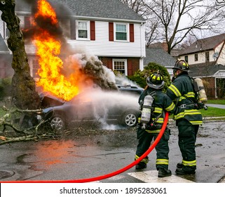 American Firefighters Use A Hose To Extinguish A Car Fire