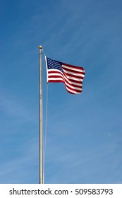 An American Flag Flying In The Air Up A Pole