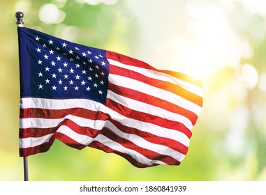 American flag flying on the background of the setting sun in nature. - Shutterstock ID 1860841939