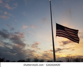 American flag half mast waving against twilight sky - Shutterstock ID 1262626420