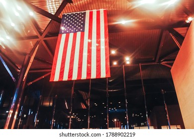 American Flag Hanging From The Ceiling In A Glass Room.