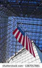 American Flag Hanging From Glass Ceiling Indoors With Blue Sky