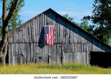American flag hanging from old weathered farm barn