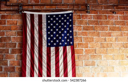 American Flag Hanging on the Brick Wall with Copy Space