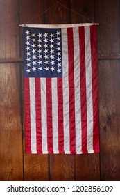 American Flag hanging vertically on wooden wall close up