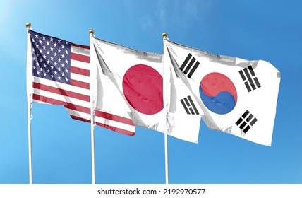 American Flag With Japanese Flag And South Korean Flag On Cloudy Sky. Waving In The Sky