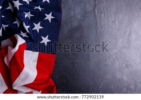 The American flag lies horizontally on the left on a gray background