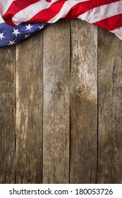 An American Flag Lying on an aged, weathered rustic wooden Background.