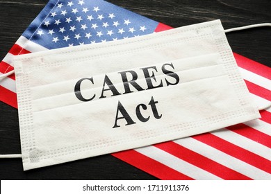 American flag and mask with sign cares act. Coronavirus Aid, Relief, and Economic Security law concept. - Shutterstock ID 1711911376
