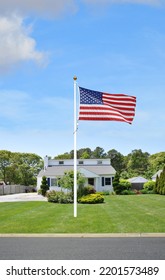 American Flag On Front Lawn Of Suburban Bungalow Home In USA