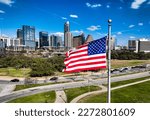 American Flag on perfect flag pole flying patriotic flag in front of the Austin Texas USA Skyline Cityscape over a capital city