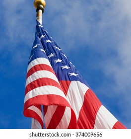 American Flag On Pole -  American Flag Hanging Down. Pole Has Gold Ball At Top.  Looking Up At Flag. 