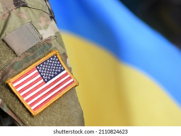 American Flag on Soldiers arm and flag of the Ukraine at background. US military support Ukraine.