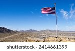 An American Flag on top of Q Mountain, in the town of the Quartzsite, in La Paz County, on the border with California, along I10 Highway, in January of 2024.