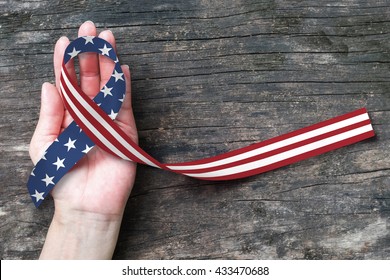 American flag pattern awareness ribbon on people's hand (isolated with clipping path) for USA United Stated of America national support and POWMIA recognition day concept - Powered by Shutterstock