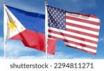 American flag and Philippine flag on cloudy sky. waving in the sky