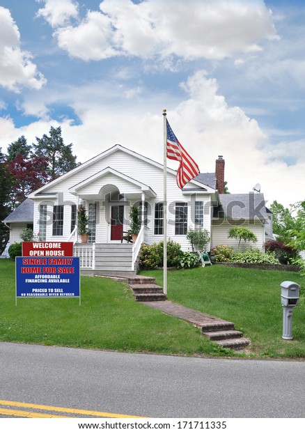 American Flag pole  real estate for sale welcome\
open house sign suburban home residential neighborhood USA blue sky\
clouds