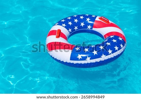 American Flag pool float. Top view of ring circle on blue water background. Summer vacation concept. Vacation in USA concept. 4th of July pool party. High quality photo