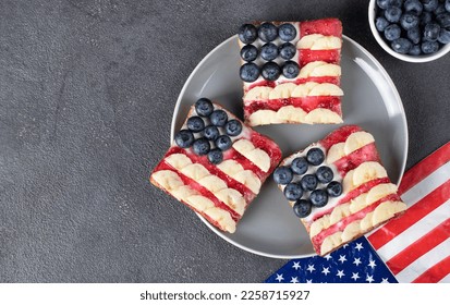 American flag sandwiches with blueberry, banana and berry jam on toast bread on gray plate, View from above - Shutterstock ID 2258715927