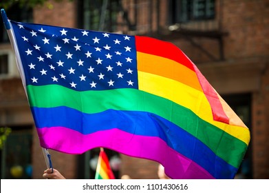 American Flag With Stars And Gay Pride Rainbow Stripes Being Waved At The Annual Gay Pride Parade In Greenwich Village, NYC