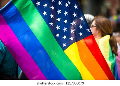 American Flag With Stars And Gay Pride Rainbow Stripes Being Waved At The Annual Gay Pride Parade In Greenwich Village, NYC