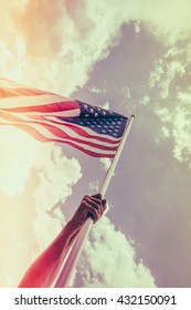 American flag with stars and stripes hold with hands against blue sky ( Filtered image processed vintage effect. ) - Shutterstock ID 432150091