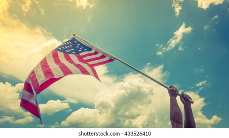 American flag with stars and stripes hold with hands against blue sky ( Filtered image processed vintage effect. ) - Shutterstock ID 433526410