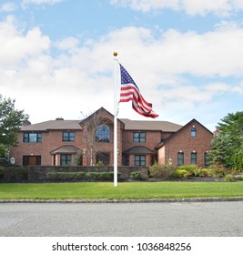 American Flag Suburban Brick Mcmansion Home Blue Sky Clouds USA