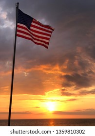 American Flag Surfing Sunset On The Pier In Florida On April 4, 2019. America The Beautiful Including Sunset, And Colorful Highlights Scenic Patriotism Beach Scene Summer 4th Of July FireWorks Freedom